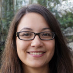 Portrait d'une femme souriante portant des lunettes, en extérieur